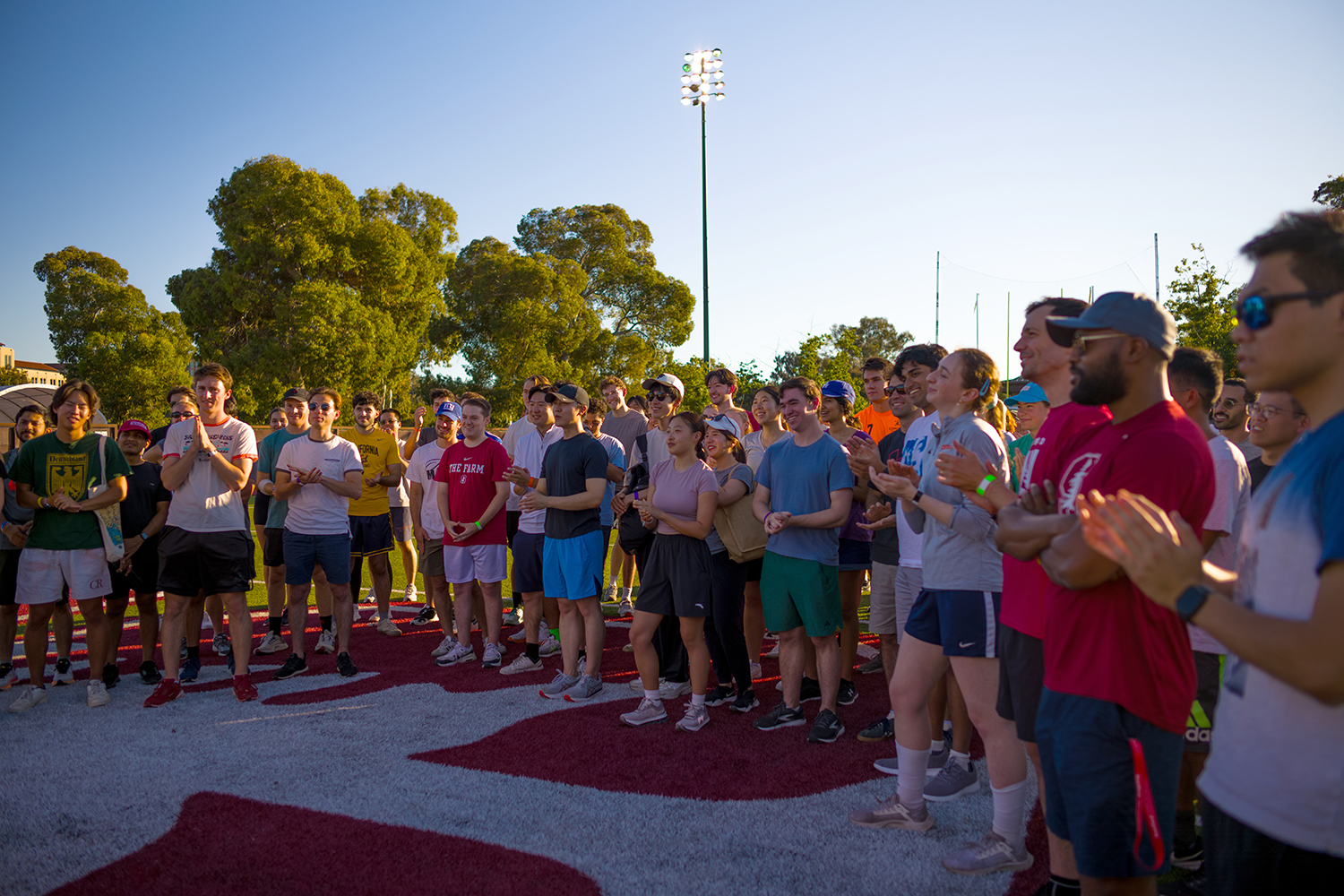 A crowd of students gathers before running football drills. 