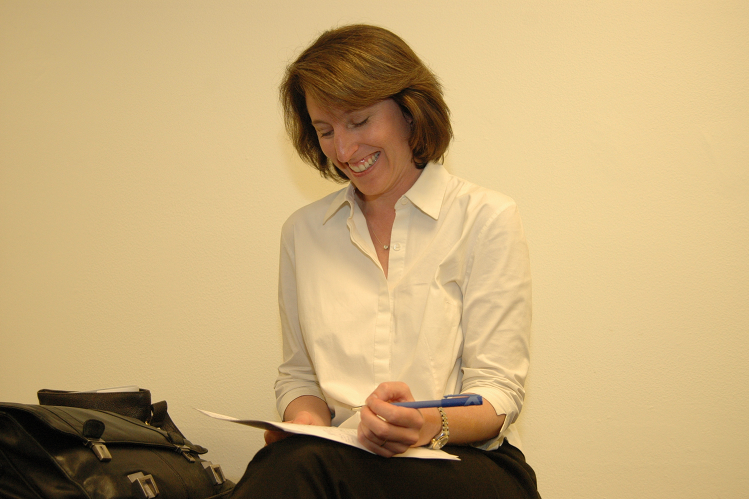 Image of Lara Tiedens writing on a packet of papers.