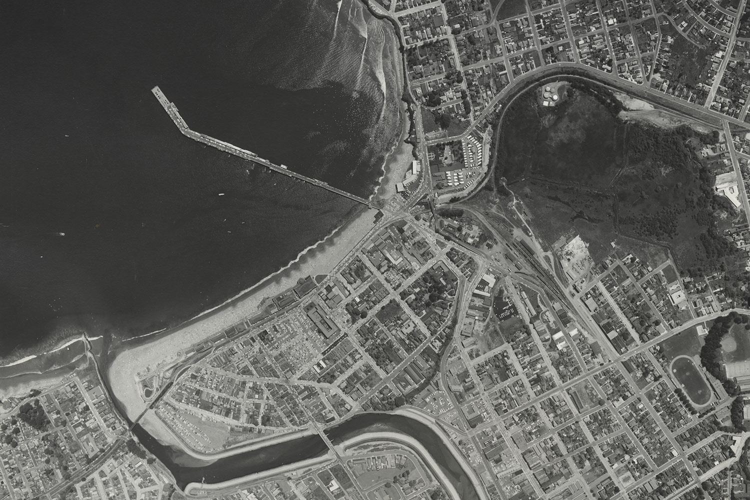 Aerial photograph from May 30, 1963, showing Santa Cruz coastal area with a pier, a river, and the layout of nearby urban neighborhoods.