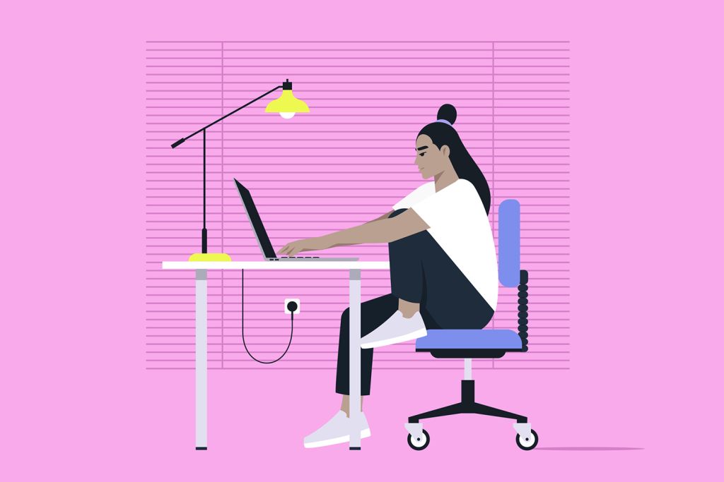 A woman works at a desk on a laptop, sitting in a chair, with a bright lamp and pink background.