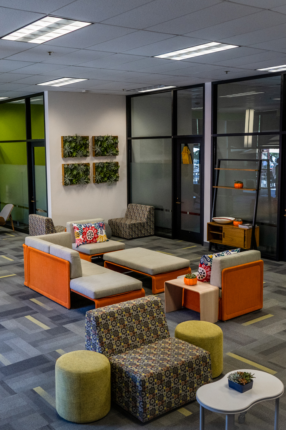 A cozy lounge area features colorful furniture and plants throughout.
