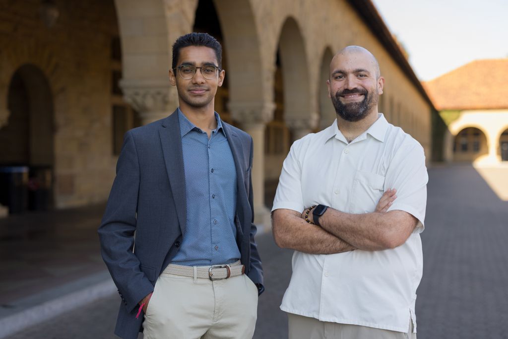 Ronak Vyas and Micky Chahcoi pose for a photo together on the Stanford campus with a sandstone arcade in the background.
