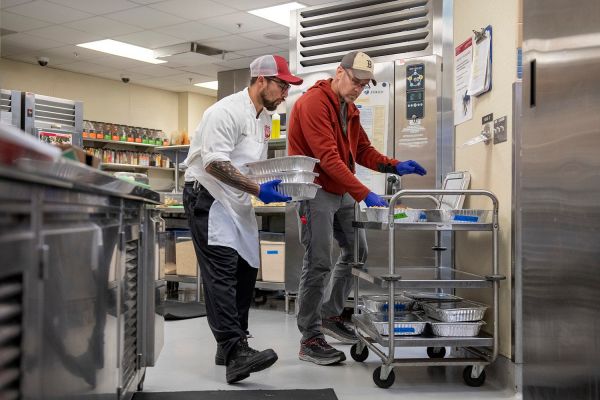 Pedro Zandoval and David Hott collect food