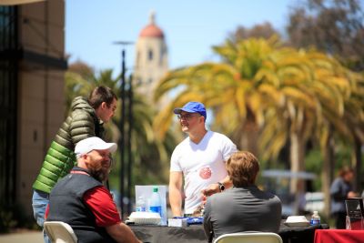 Staff members speaking to students at a table.