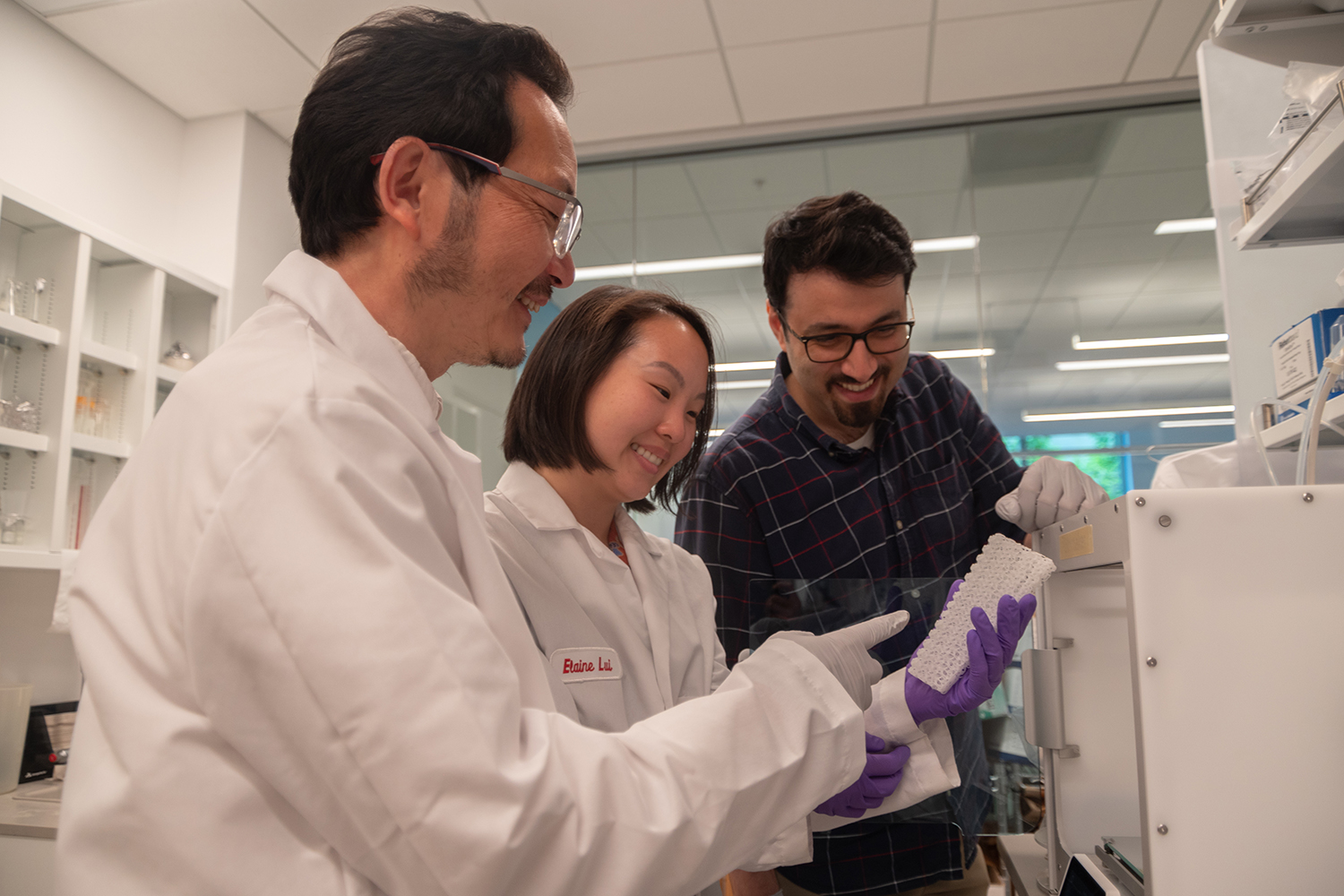 From left to right, orthopedic surgery Professor Yunzhi Peter Yang discusses with co-inventors Dr. Elaine Lui and Dr. Hossein Vahid Alizadeh a bone scaffold for use in bone grafting surgery.