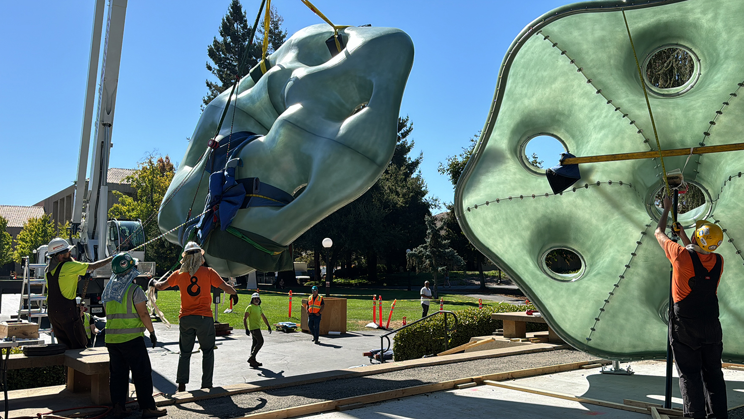 Image of a crane lifting the sculptures into place.