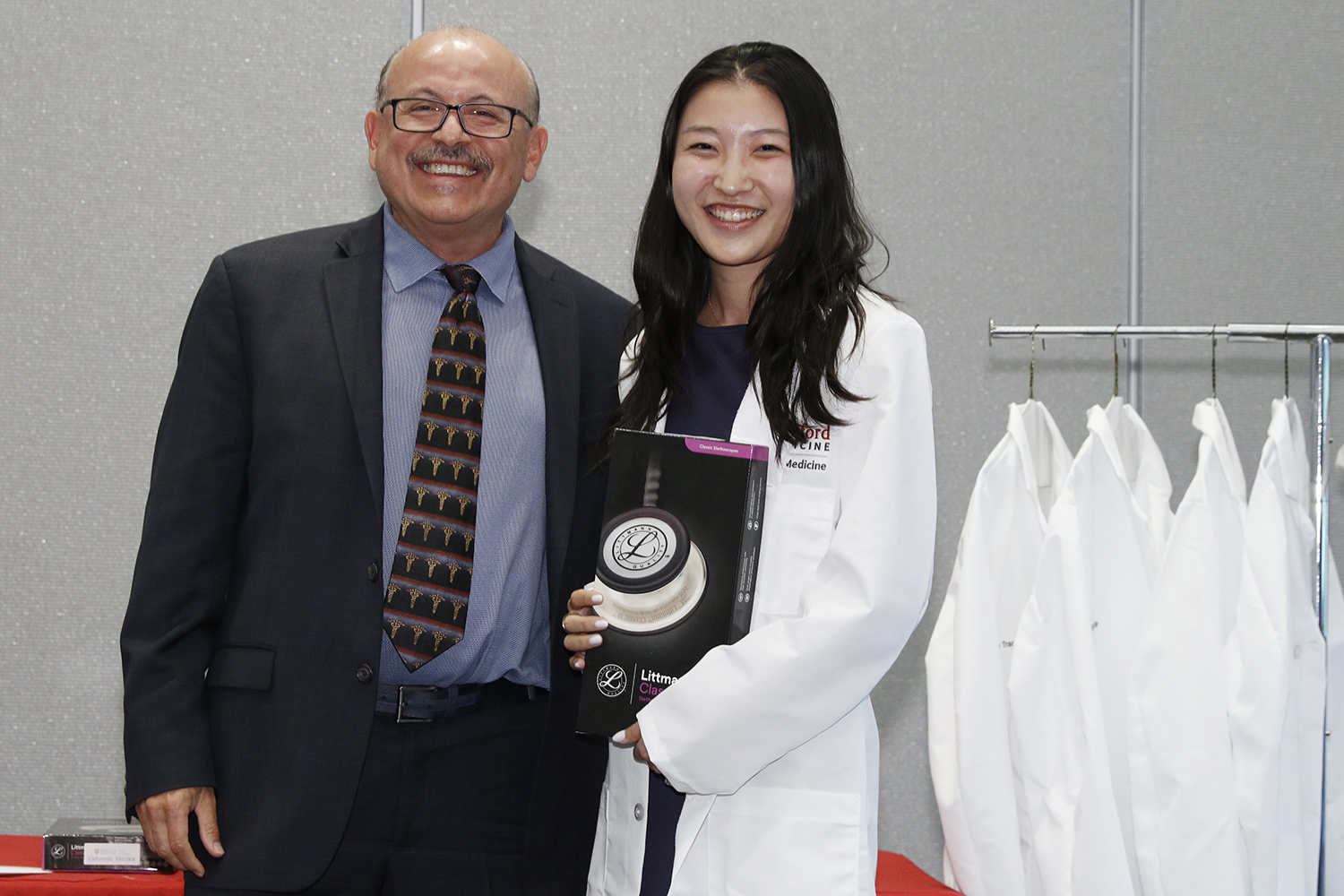 Female student receives her white coat and stethoscope.