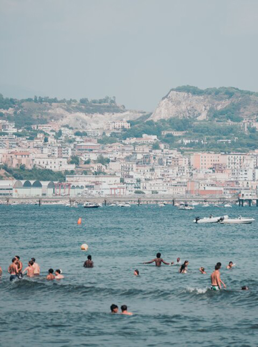 Image of people swimming near Baia beach, Pozzuoli in Campi Flegrei, Italy.