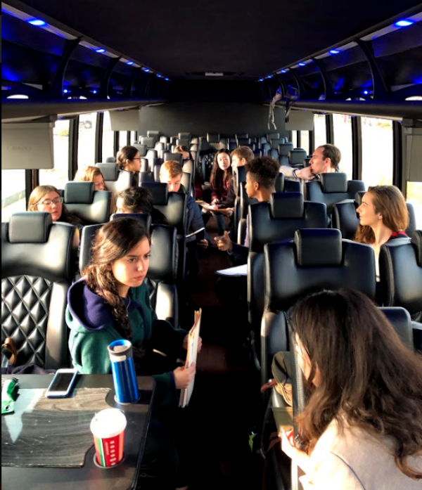 Students sitting on the bus and talking.