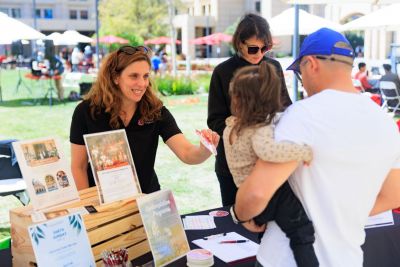 Staff members speaking to students at a table.