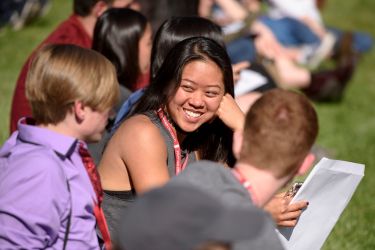 Students sit on the grass in Frost Amphitheater