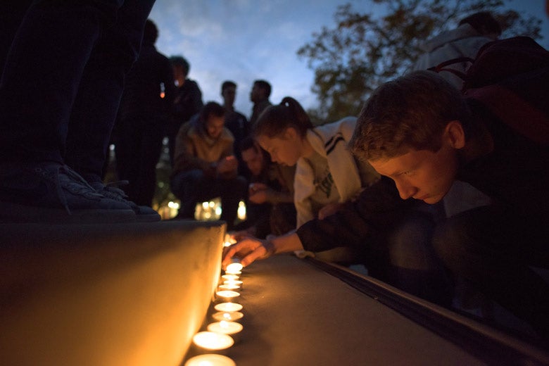 Students lighting candles at vigil