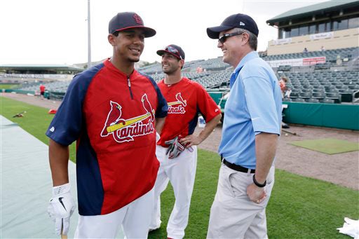 Feb. 25, 2013, file photo of Houston Astros general manager Jeff Luhnow, right, talking to St. Louis Cardinals center fielder Jon Jay, left, and second baseman Daniel Descalso