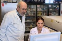 two people in lab coats looking at computer