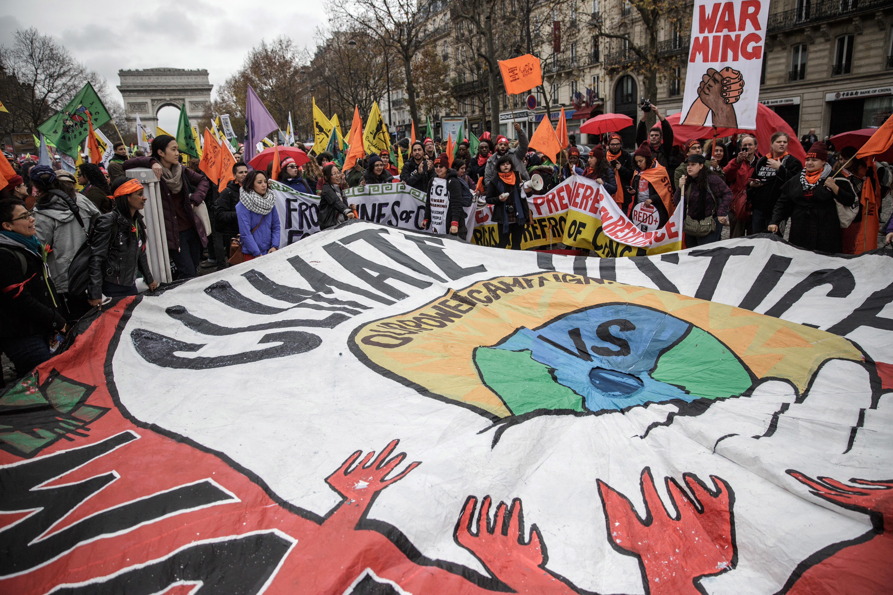 Activists hold a giant banner reading "Climate justice"