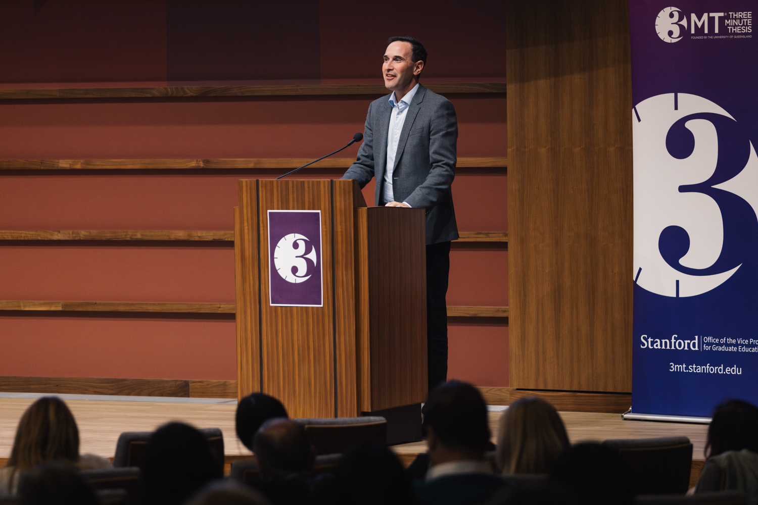 President Jonathan Levin at the lectern emcees the 3-Minute Thesis competition