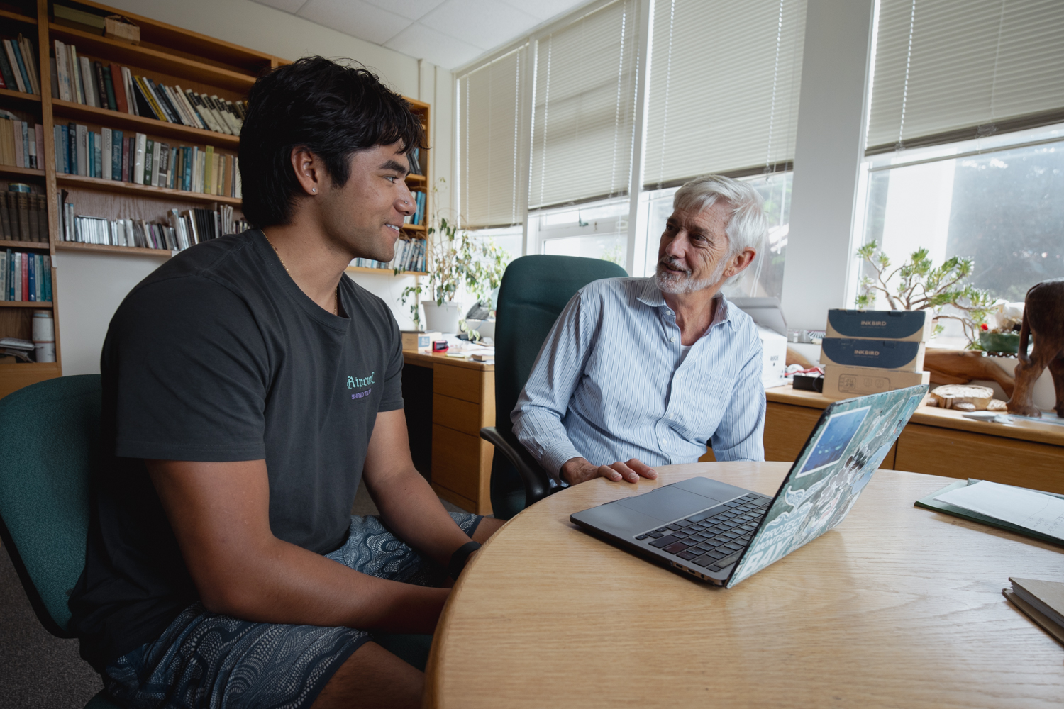 Image of Stephen Palumbi and a student talking in a office.