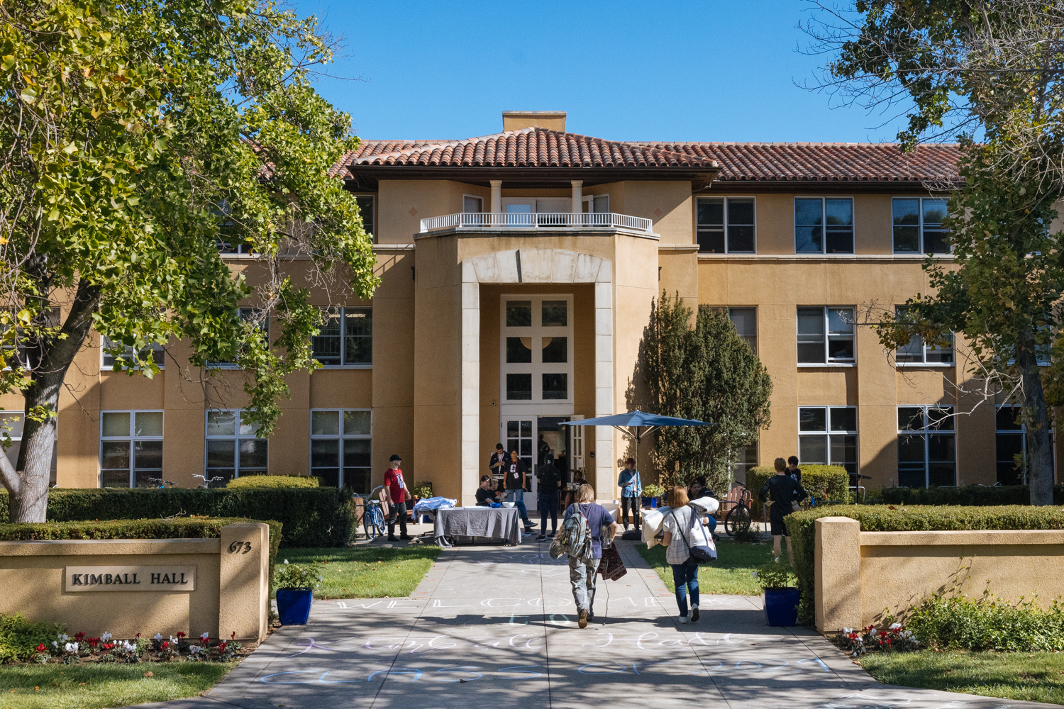 Students carry belongings as they move into Kimball Hall.