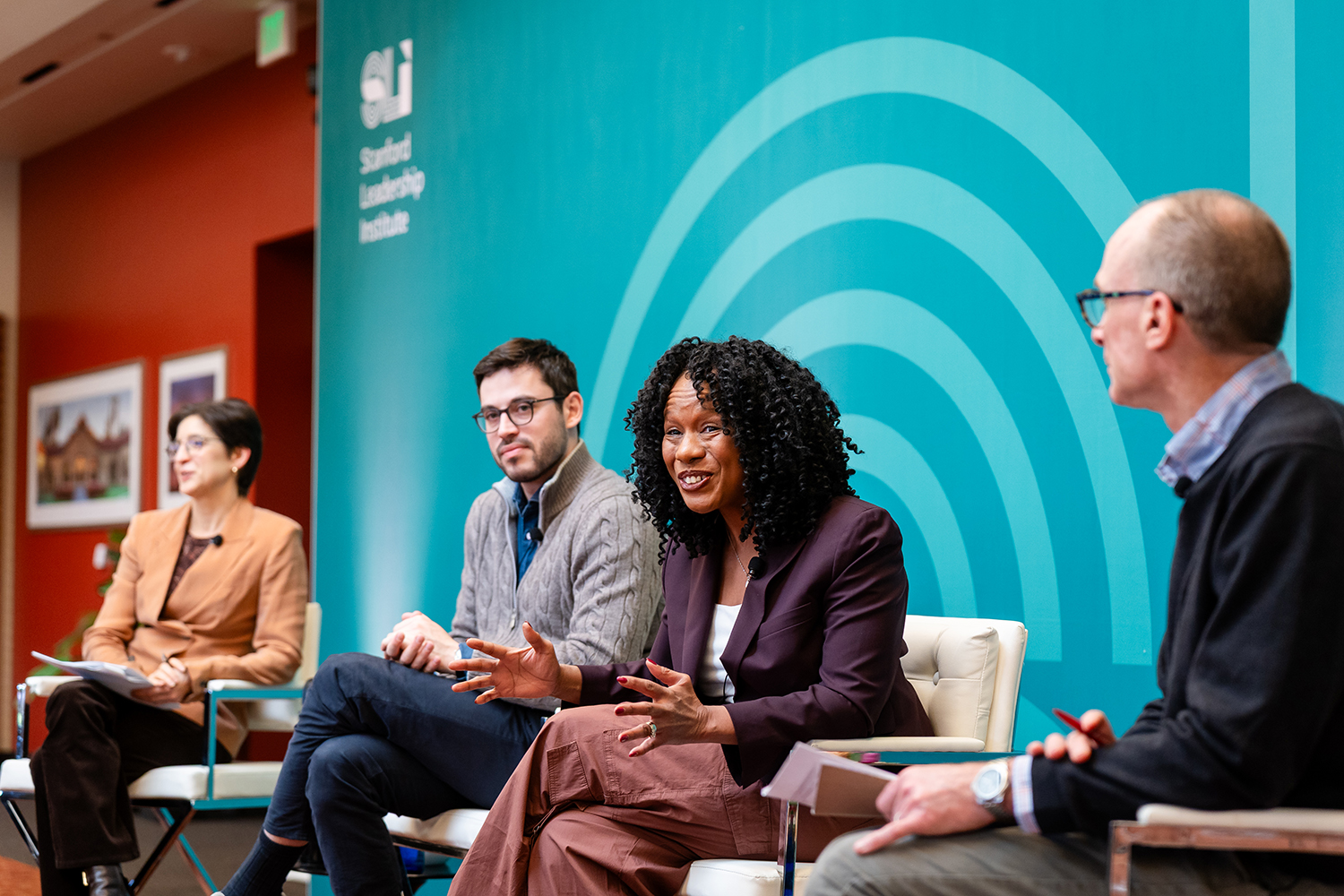 A panel discussion at the Stanford Leadership Institute, featuring four speakers engaging in conversation.