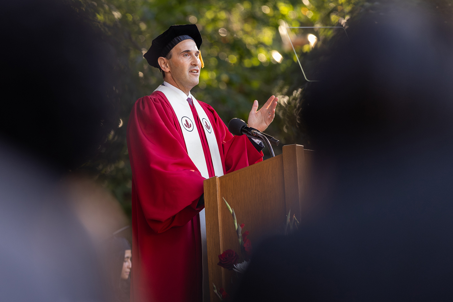 Open video President Levin in red academic regalia and speaking at a podium outdoors. in a modal