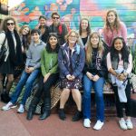 students in front of a mural in San Francisco's Mission District