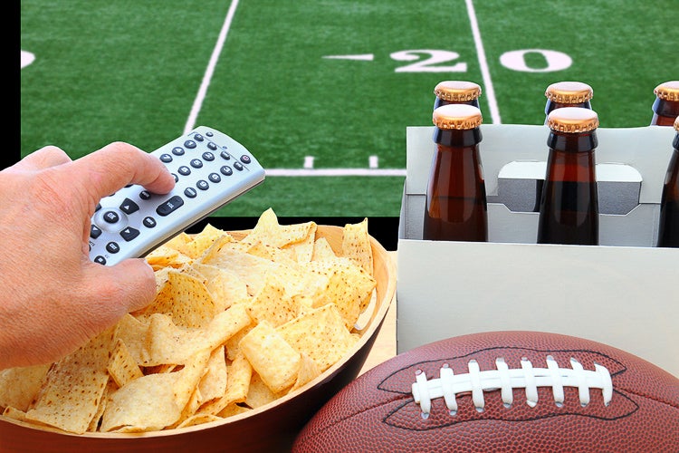 closeup of chips, beer and remote with gridiron in the background