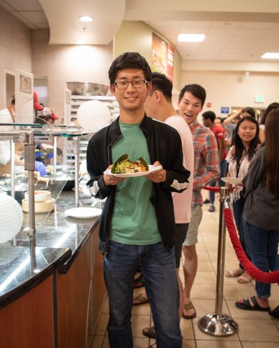 Student holding a plate with a roll.