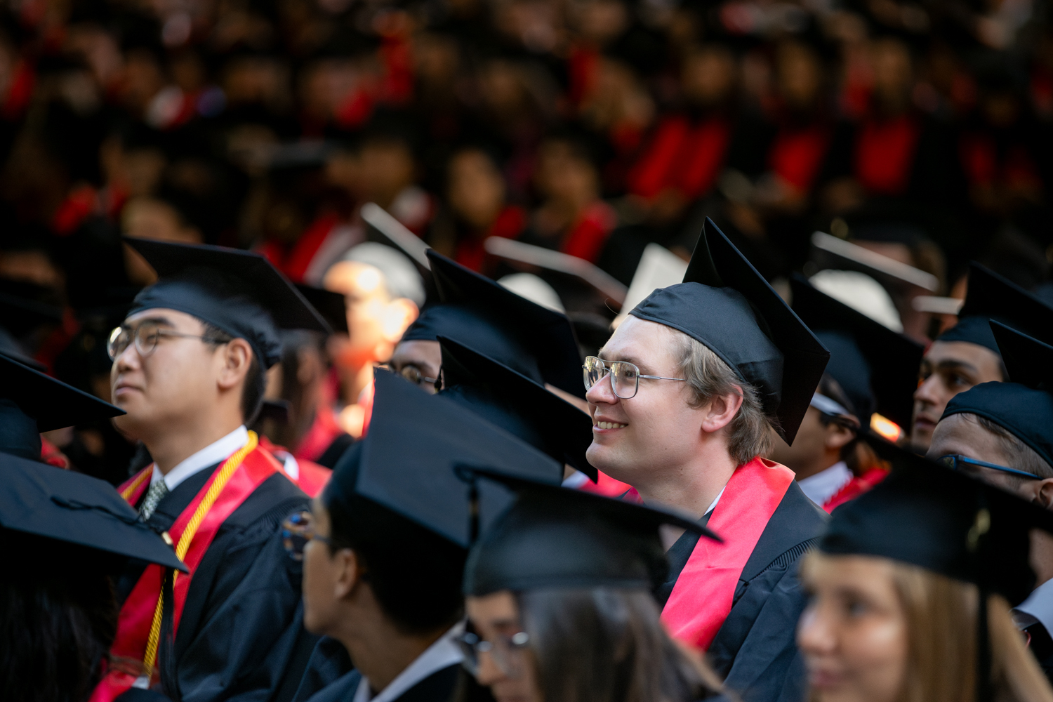 Grads in the crowd look to the stage