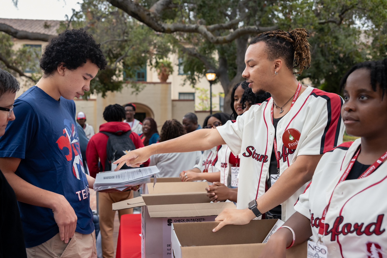 A student on the welcome team at Ujamaa, the African American-themed residential hall, gives a new student some information.