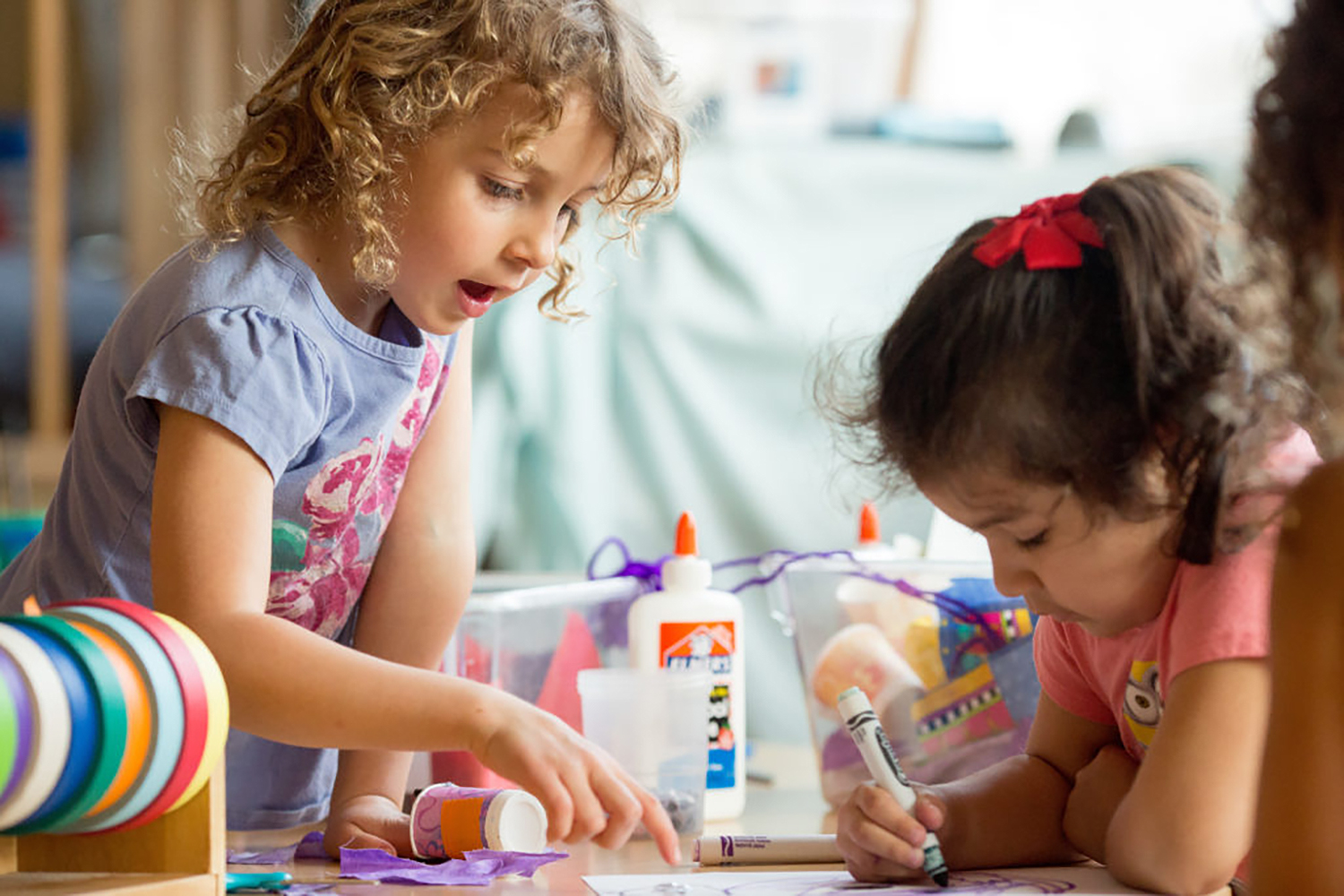 Image of two preschool girls doing arts and crafts.