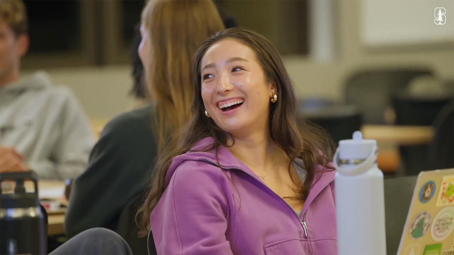 Atira O'Neil sitting in class and laughing to something that was said by the instructor.