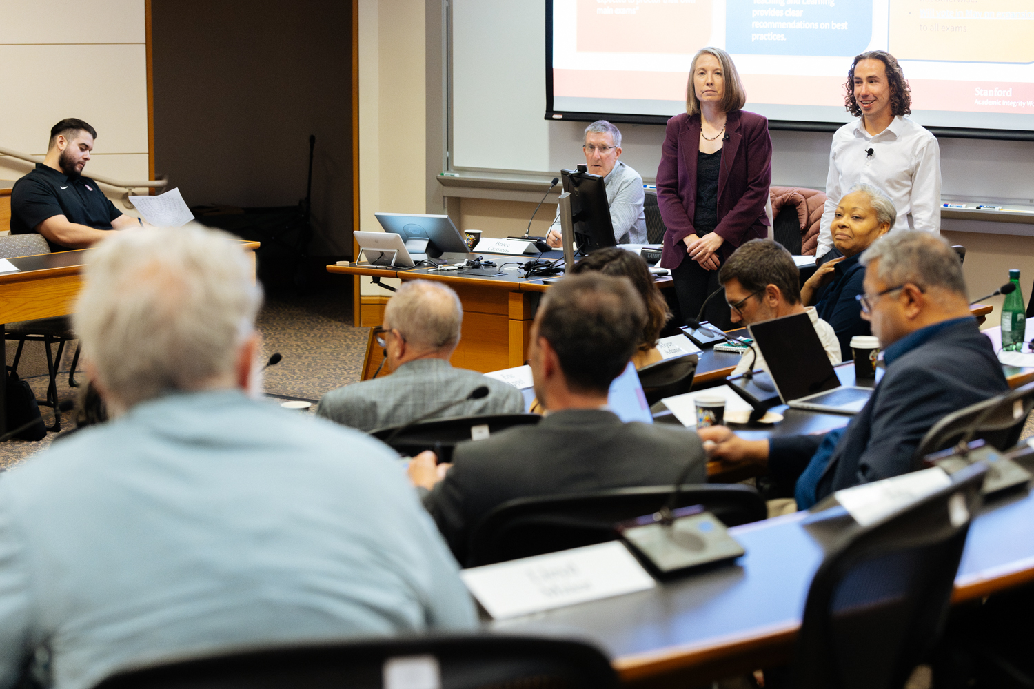 Two people giving a presentation during a Faculty Senate meeting.