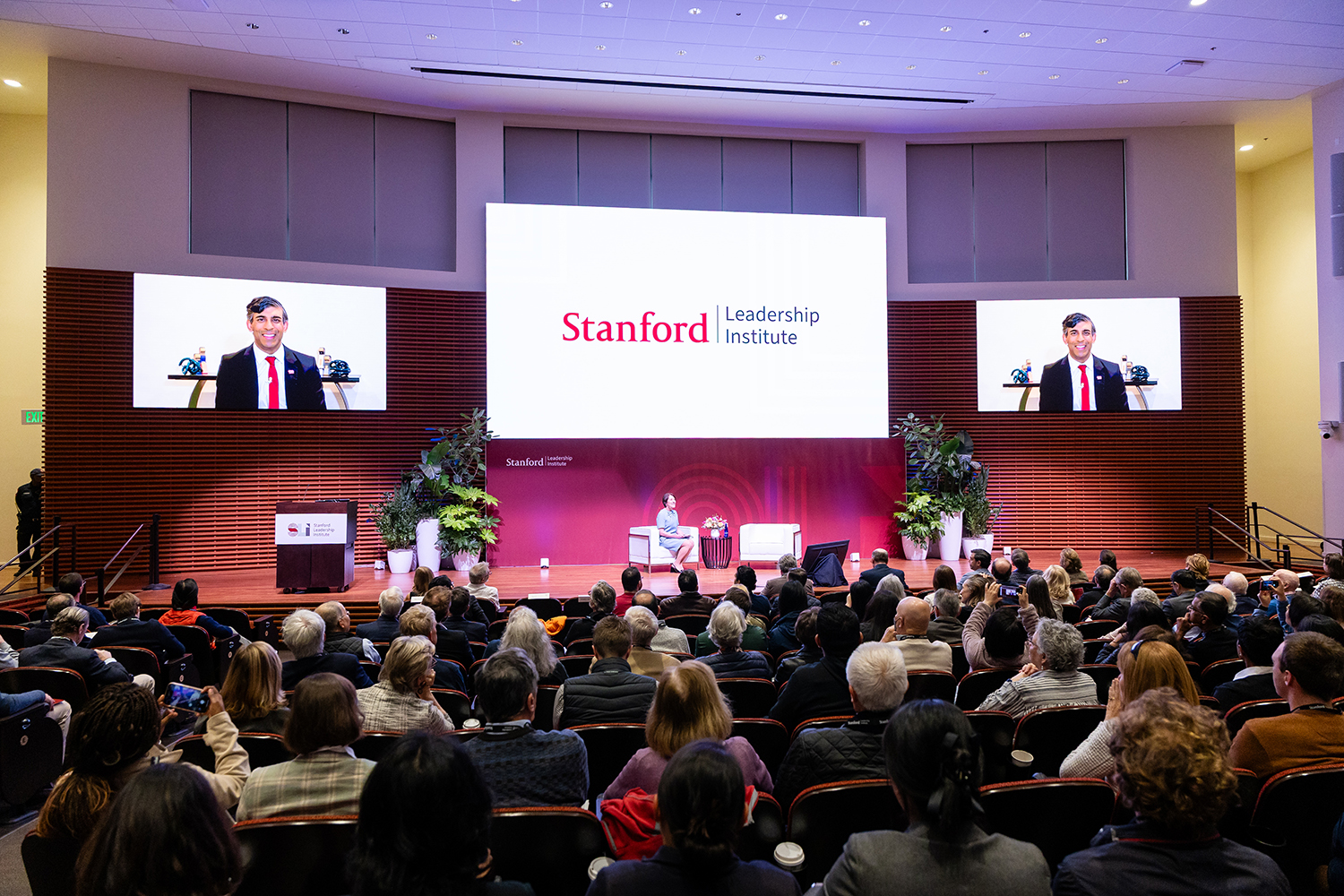 A discussion at the Stanford Leadership Institute event, with an audience engaged and visible in a large auditorium setting.