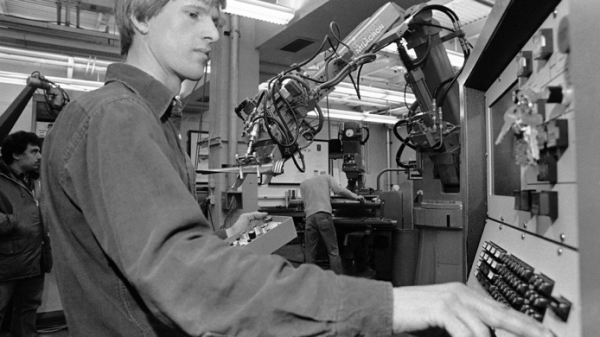 Cutkosky at a machine with a robotic arm next to him