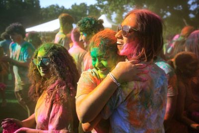 Students covered in colored dust, smiling.