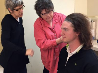 For a production of Shakespeare’s The Tempest, Costume designer Connie Strayer and wig designer Kerry Rider-Kuhn fit Prospero’s wig on Tim Schurz.