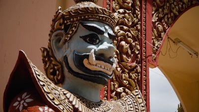 close-up of the face of an ornately carved and painted wooden statue