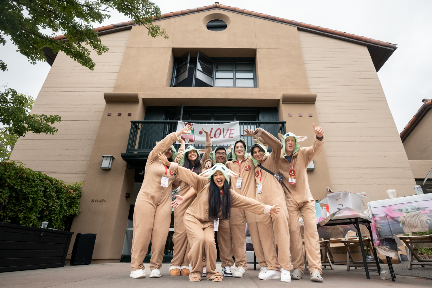 Open video A group of young people dressed in Baby Yoda costumes pose in enthusiastic welcome. in a modal