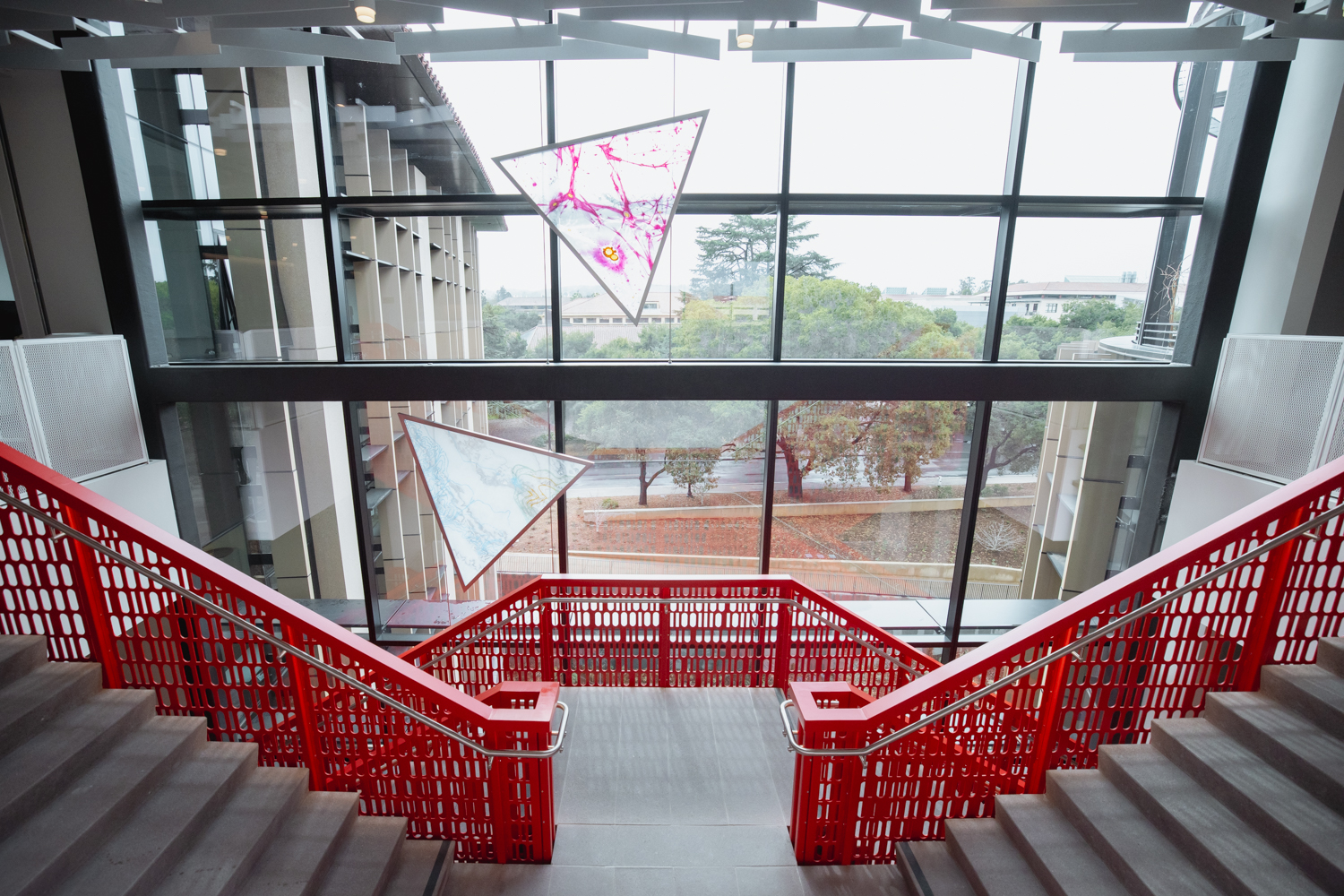 Winding through staircase are  hand-painted and etched triangular glass panels by artist Camille Utterback that depict historical and contemporary methods of encoding or working with data.