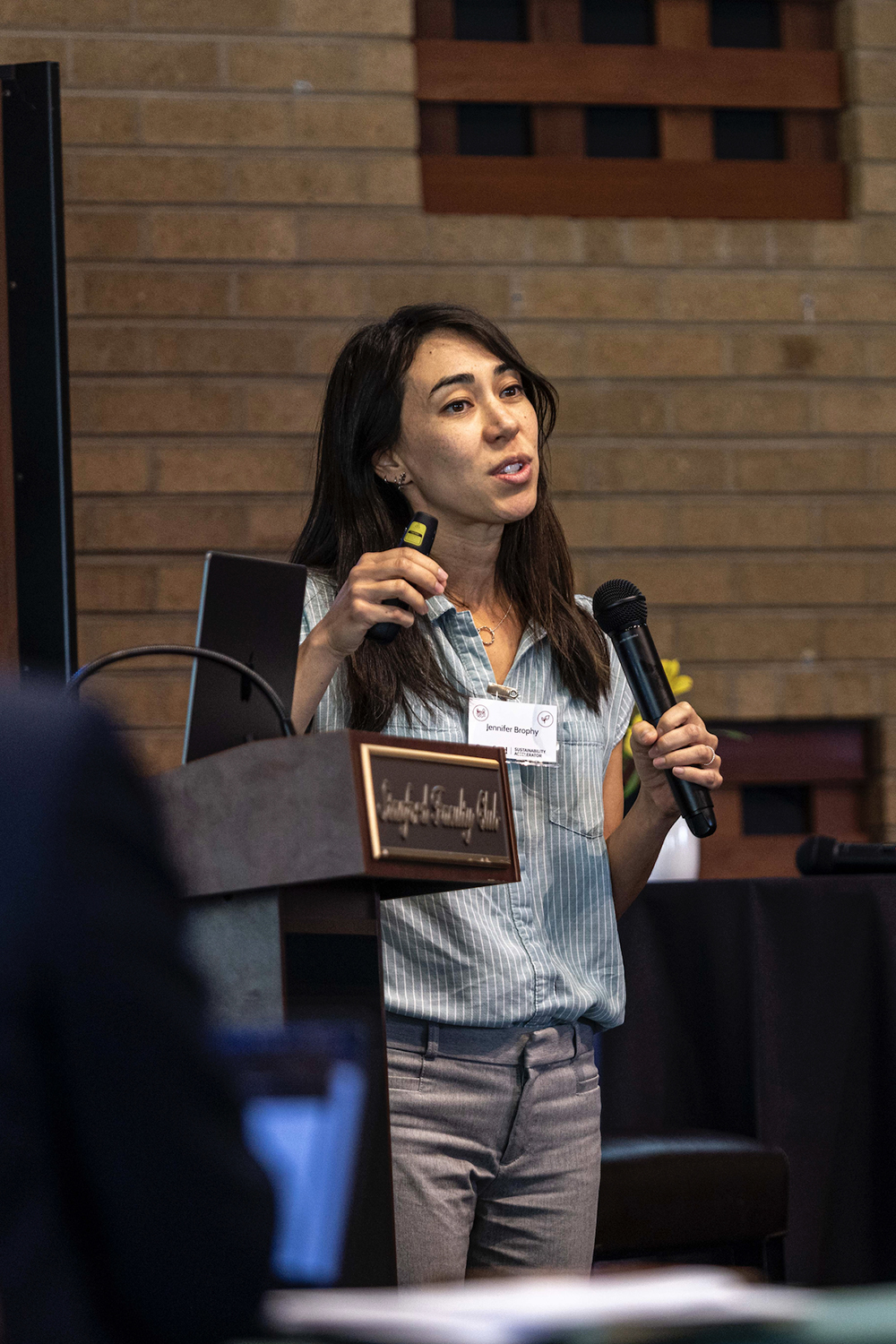 Jennifer Brophy presents at a conference, speaking into a microphone.