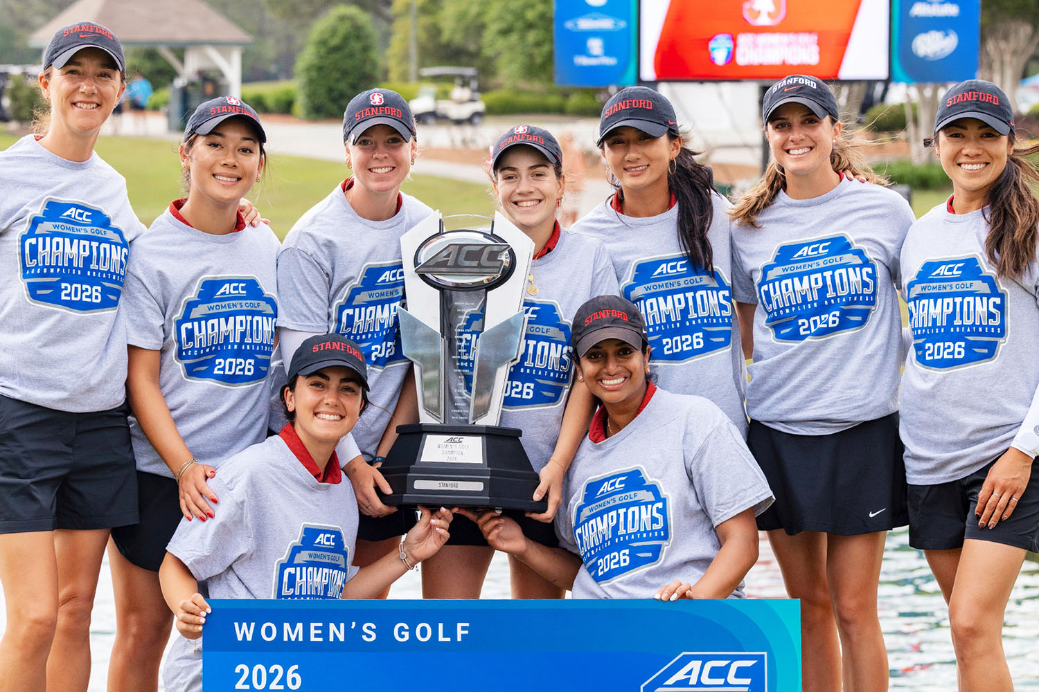 Stanford women's golf team celebrates their 2026 ACC championship victory while holding a large trophy.