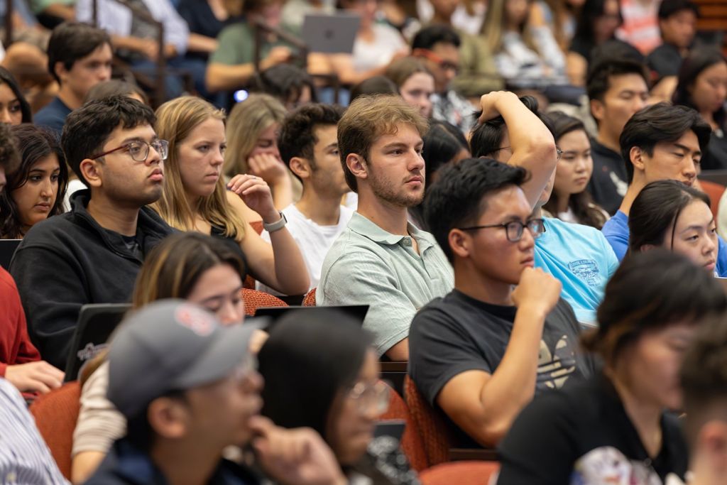 Attentive students in a crowded lecture hall.