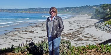 Nancy Dudley standing by the beach.