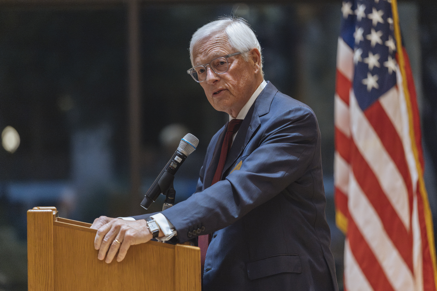 Palo Alto Mayor Ed Lauing in a dark blue suit stands at a lectern and delivers remarks at the 2025 Veterans Day ceremony.