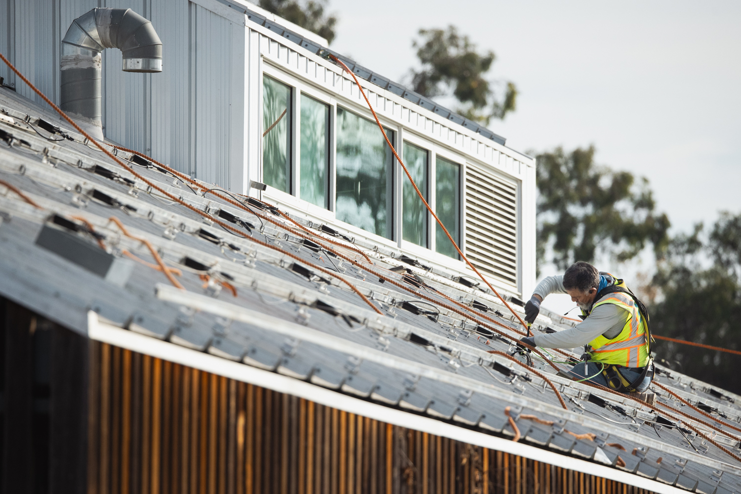Image of a person installing the foundation for solar panels on the roof of the O'Donohue Family Stanford Educational Farm.