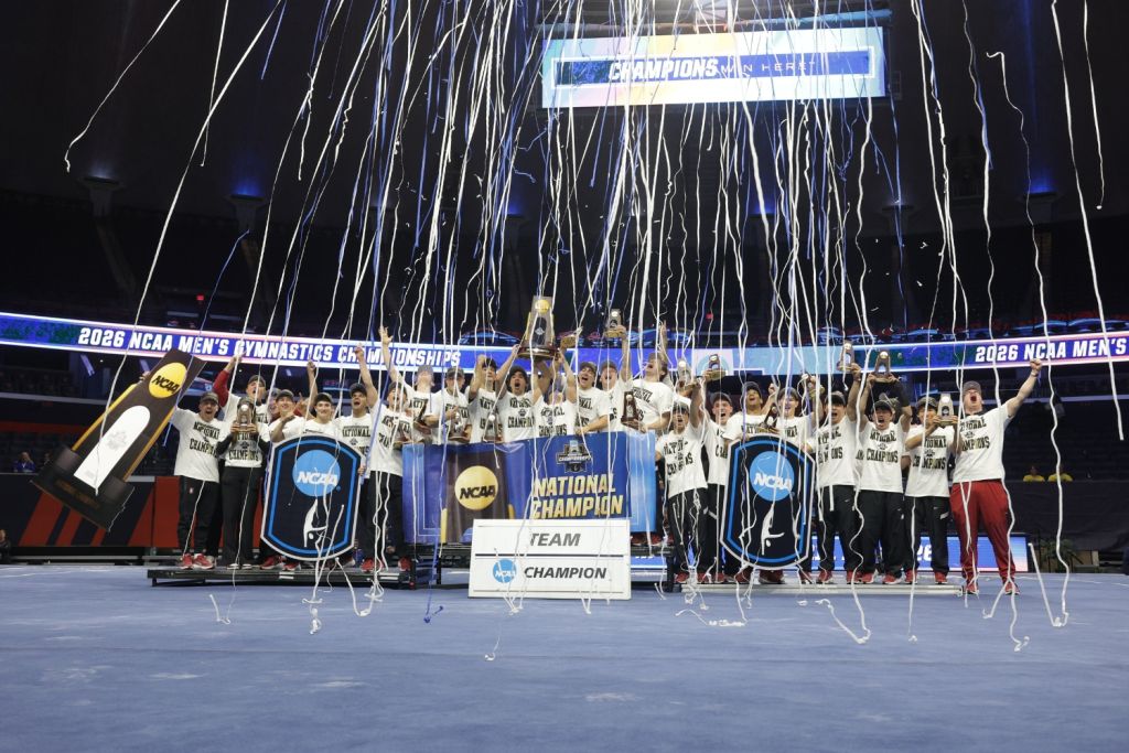 The men's gymnastics team poses for a photo while celebrating their NCAA Championship win.