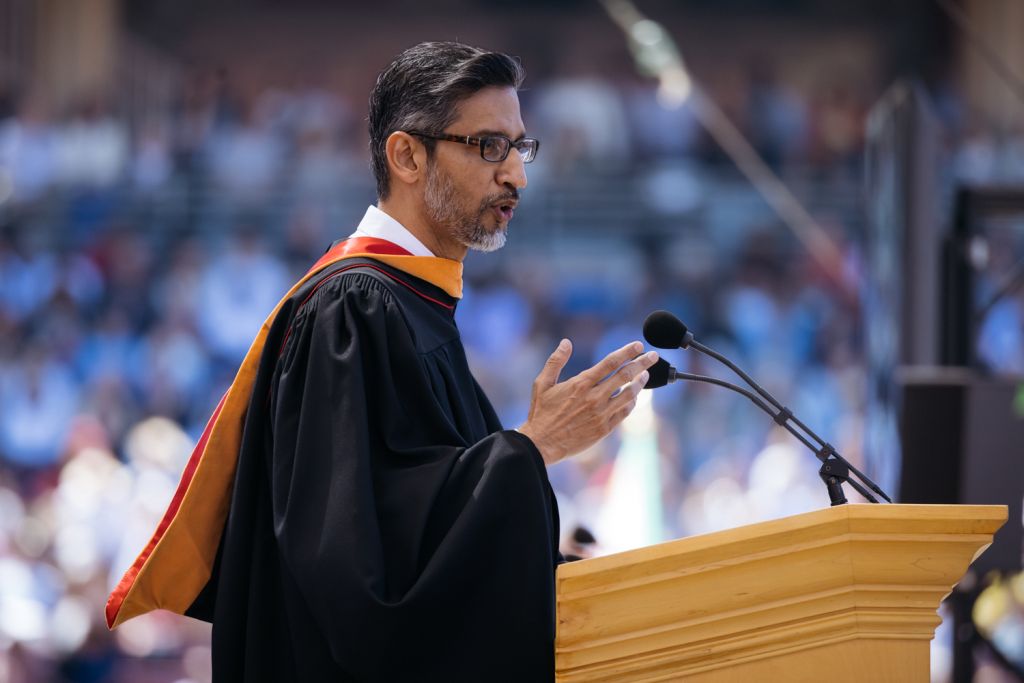 Open video Sundar Pichai addresses graduates from a podium, delivering a speech during Commencement ceremony outdoors, with an audience in the background. in a modal