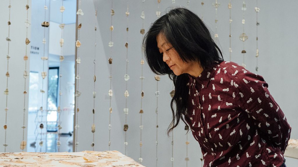 Open video Patty Chang looks at an installation from her exhibit, “Patty Chang: surfacing.” in a modal