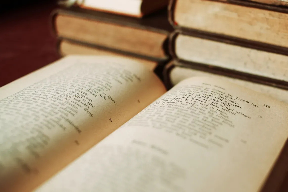 Old books, with one in foreground sitting open