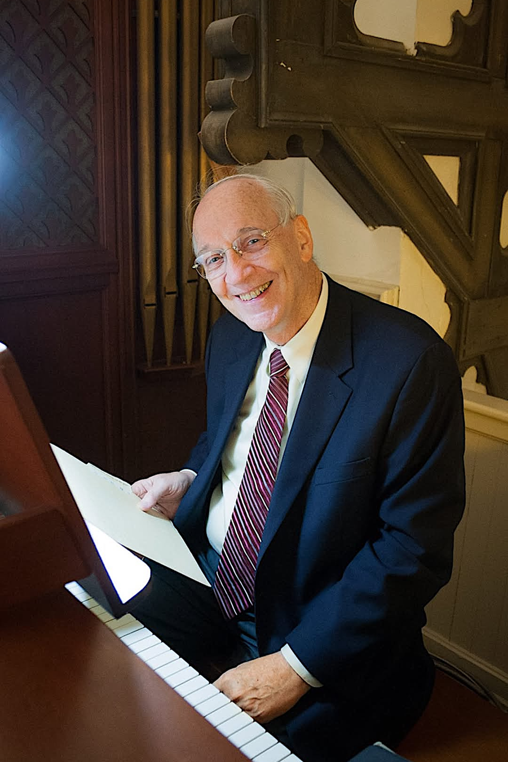 Profile photo of William P. Mahrt sitting at a piano.